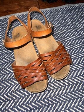 Women’s brown, leather, wooden clogged sandals.